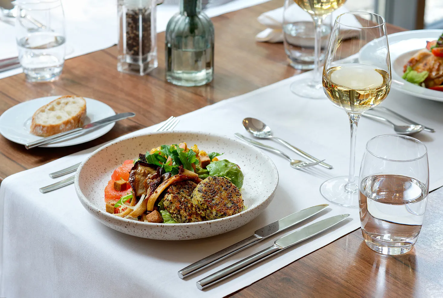 Veganes Mittag- oder Abendessen im Mövenpick Restaurant Münster mit einem Glas Weißwein: Vegane Bowl mit Quinoabratling
